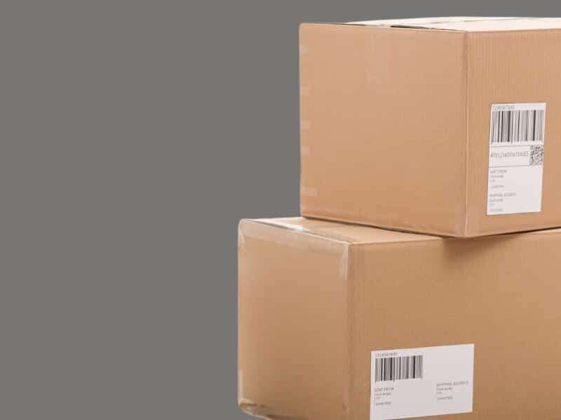 Header image for blog titled Amazon SP-API: Everything your business needs to know. Plain mid-grey background with cut-out image of a stack of two cardboard delivery boxes.